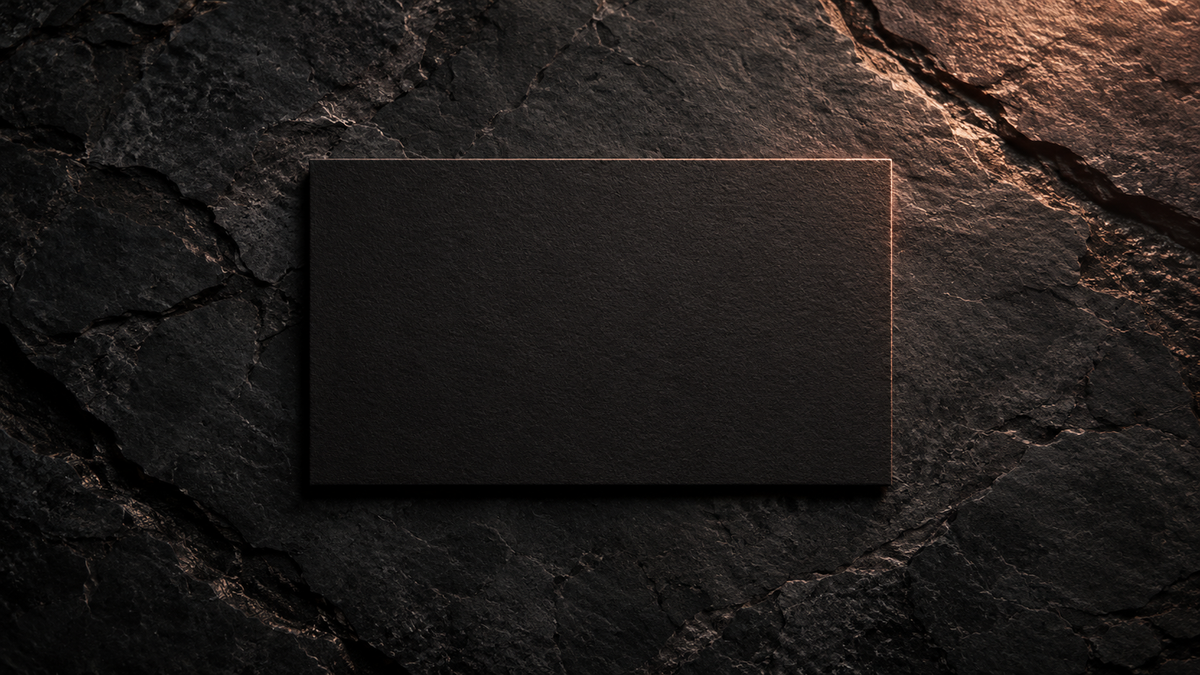 Single unmarked black card on a plain dark stone surface